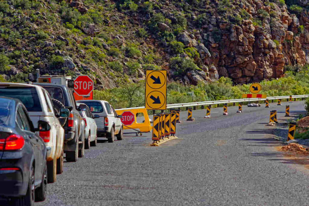 Traffic backup at a highway stop point with multiple vehicles and road signs near a construction zone on a mountainous road in Iredell County, North Carolina, illustrating travel disruption from wrong-way driving and impairment-related collision on I-7