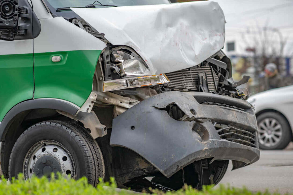 Damaged ambulance in fatal North Carolina crash, showing front-end impact with visible gurney and vehicle damage, after 92-year-old patient thrown during collision.