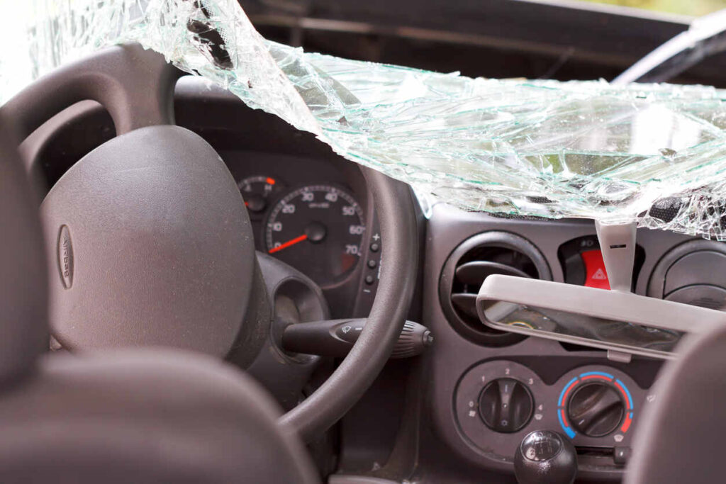 Interior of a car after a severe head-on collision, showing a shattered windshield, deployed airbag, and damaged dashboard, illustrating the devastating impact of a suspected DUI crash in NC.