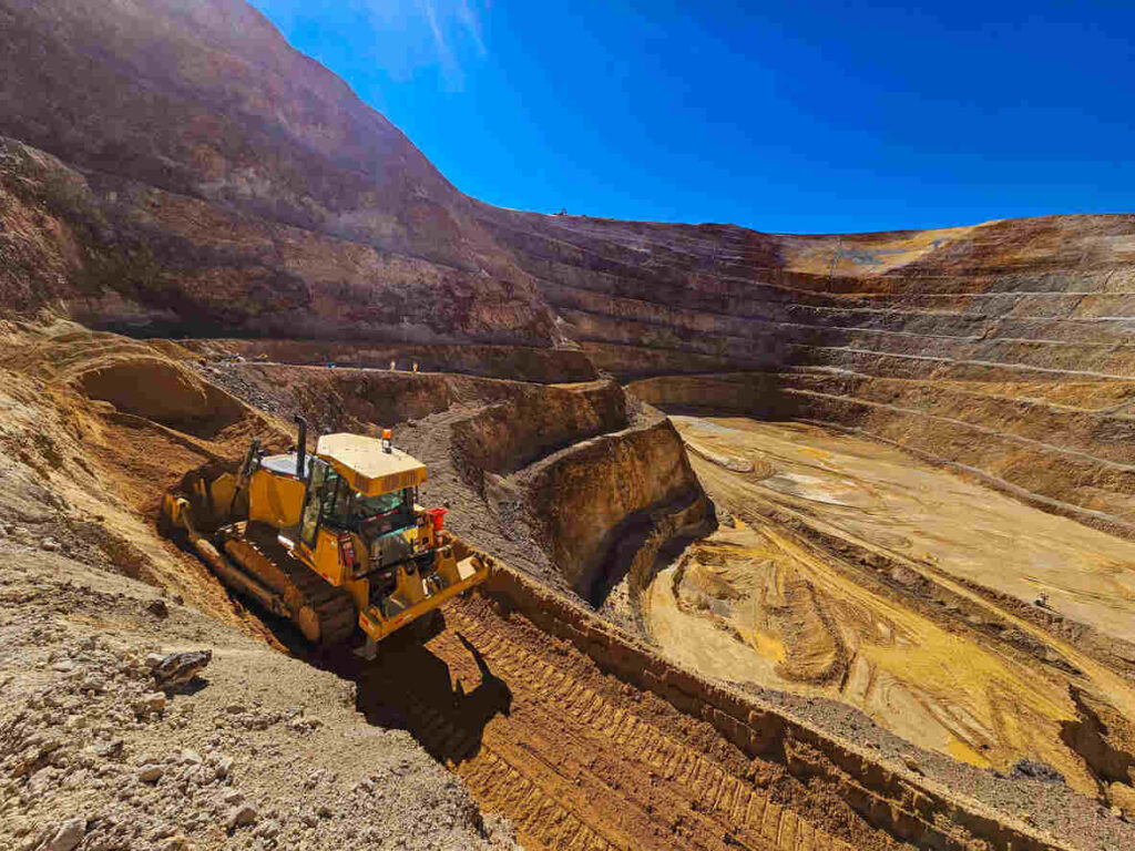 Bulldozer working in a sandpit with steep slopes in Tyrrell County, highlighting the operator's dangerous environment.